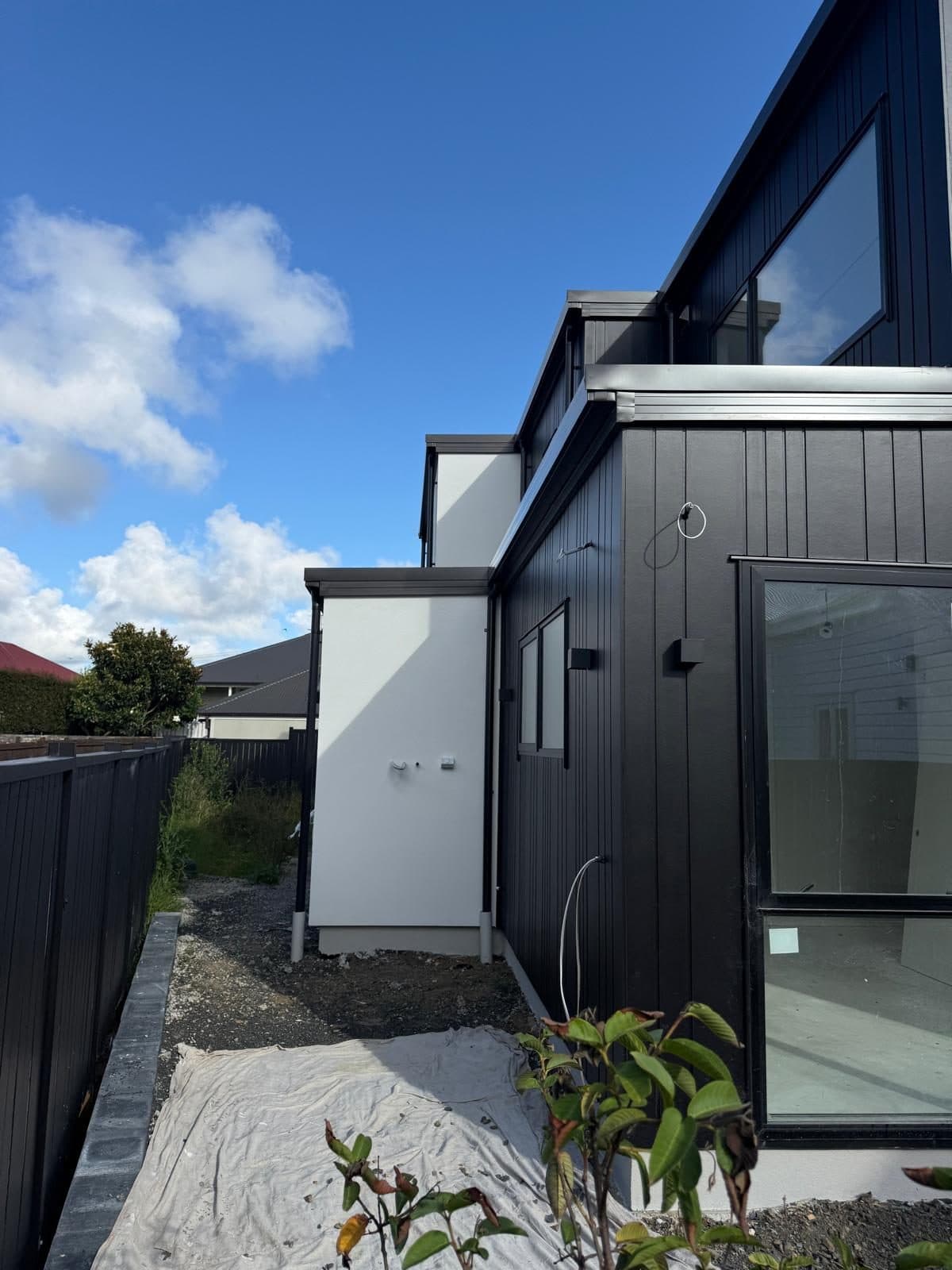 Nagra Constructions residential project with dark exterior cladding and white plaster finishes