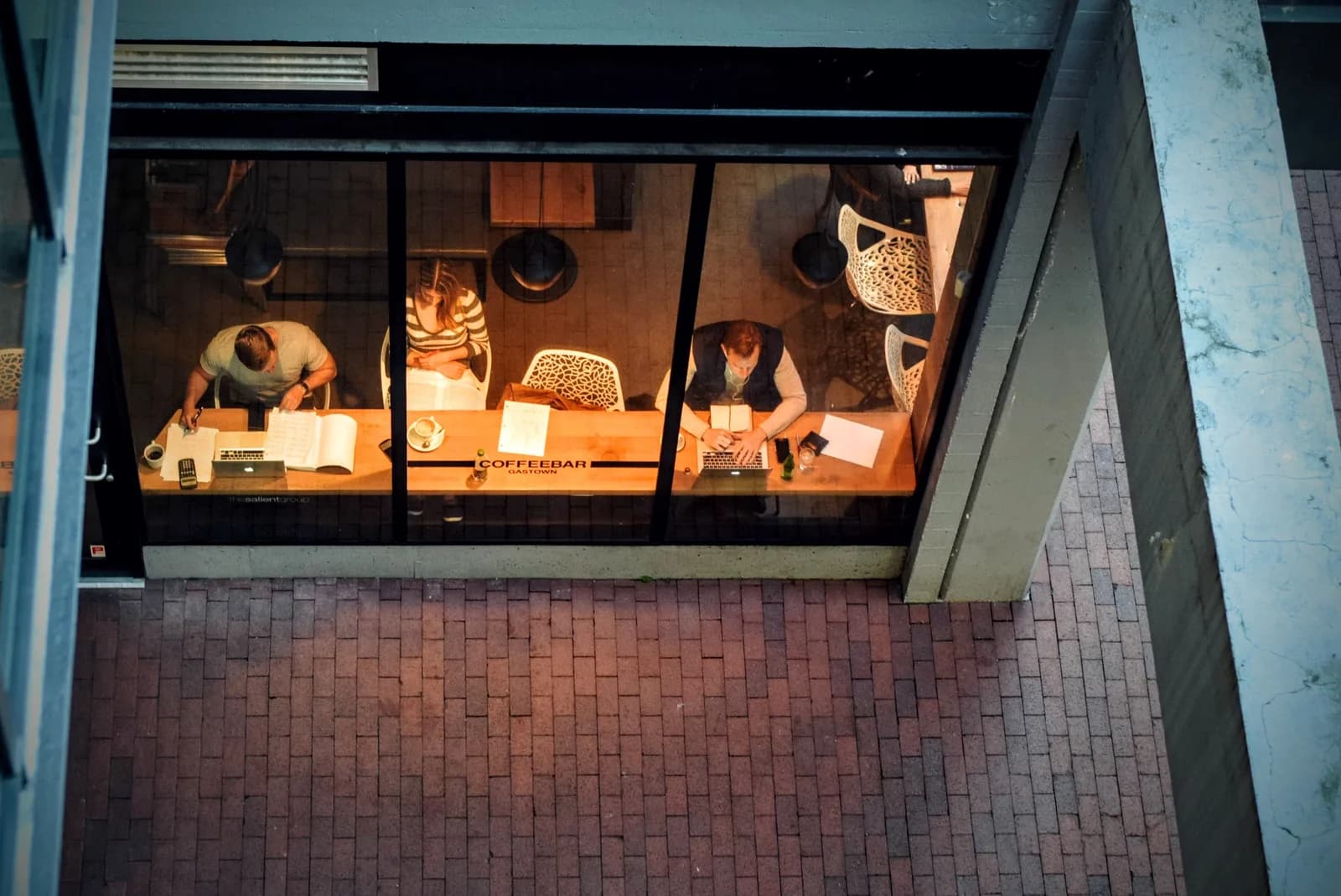 Business owners working on laptops at a busy cafe
